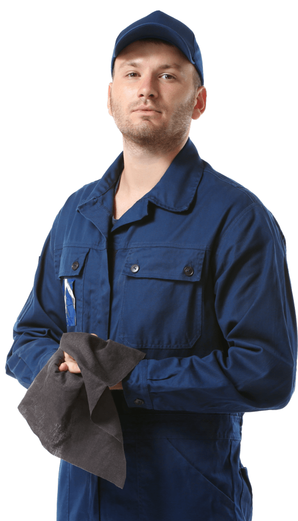 A mechanic in a blue work jumpsuit and cap holds a dark cloth, displaying a confident expression. This image represents skilled labor in maintenance or repair contexts.